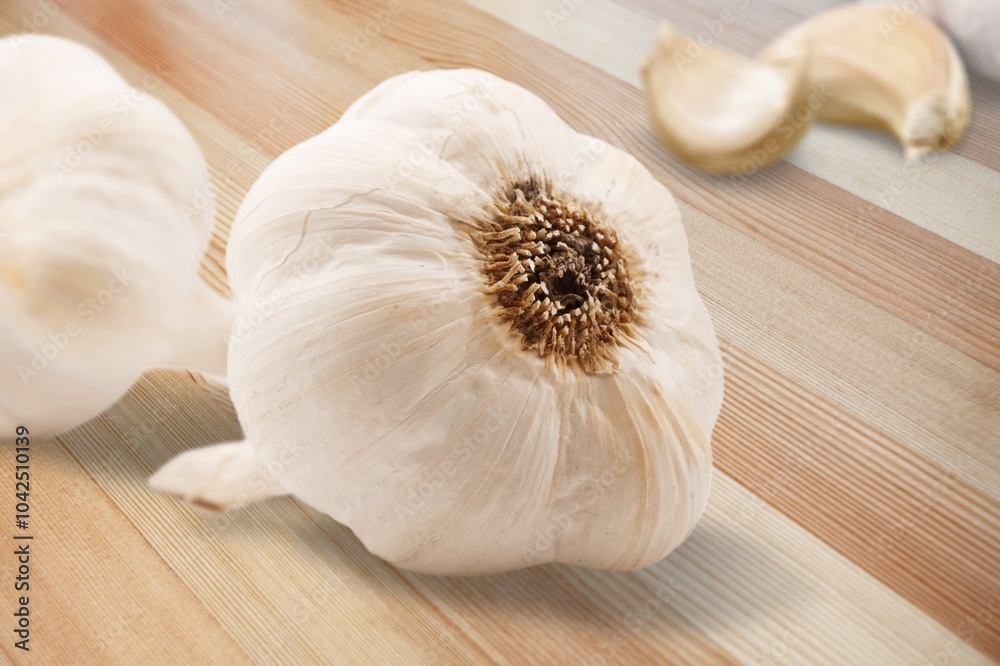 Poster Aromatic fresh garlic cloves bulbs on table