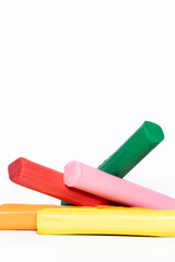 Variety of colorful plasticine sticks: red, pink, green, yellow and orange stacked in a disorderly...