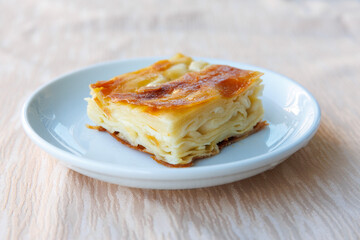 Delicious Turkish Tray pastry, Su boregi with cheese. Adana borek on white plate. Side view close up