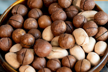 Macadamia nuts in a wooden plate. fitness and diet, healthy lifestyle.