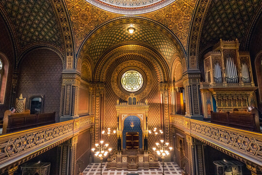 Interior of the Spainsh synagogue in Prague with golden walls and warm lighting
