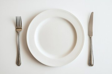 A white plate with a fork and a knife on a white background.