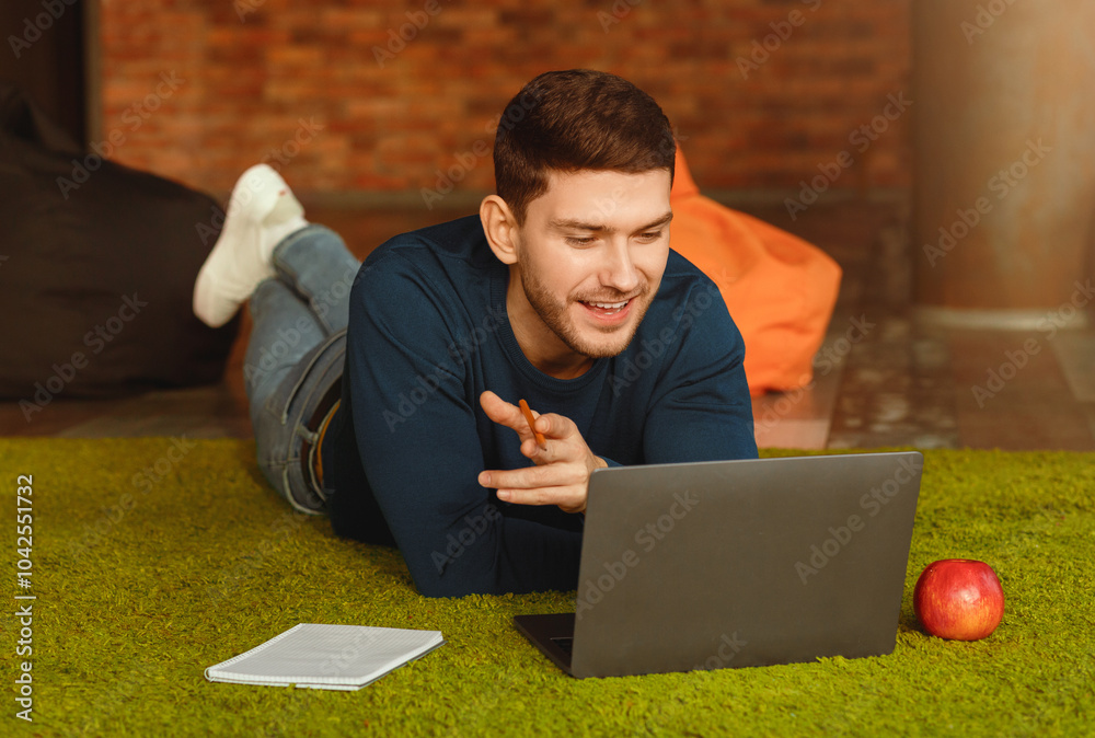Poster freelance career. guy using laptop making video call communicating with distant clients lying on flo