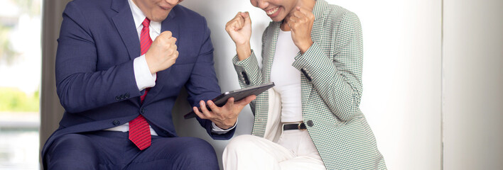 Two young business man and woman in formal meeting and discussing documents and using a tablet in modern office, businessman planning with partner or consulting, business and team concept.