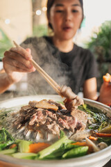 Happy asian woman enjoy her delicious Thai BBQ Buffet.