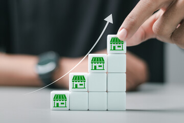 Franchise marketing system in global business network and brand building. Person stacking wooden...