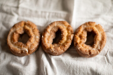 three sourdough donuts on a white tablecloth 