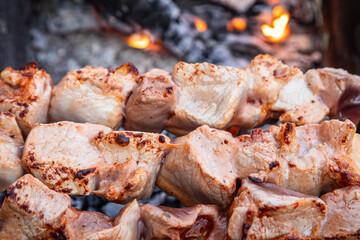 Cooking meat pork kebabs on flaming grill with selective focus