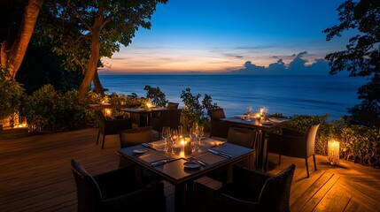 Elegant resort with an outdoor dining area overlooking the ocean at dusk with soft candlelight and breathtaking views