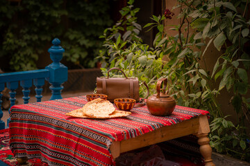 The table outside on a terrace with copper teapot and Uighur bread in Kashgar Old Town