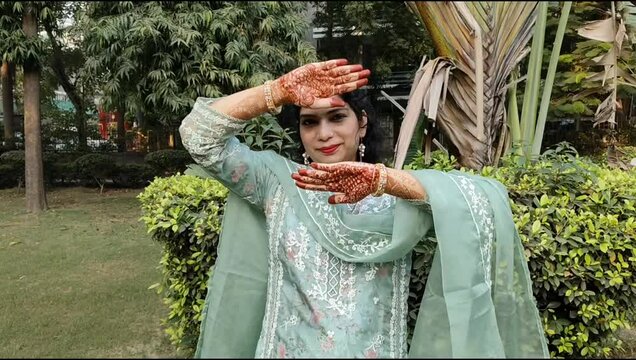 Beautiful woman dressed up as Indian tradition with henna mehndi design on her both hands to celebrate big festival of Karwa Chauth, Karwa Chauth celebrations by Indian woman for her husband