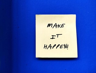 Note stick on blue wall with handwritten text MAKE IT HAPPEN!, idiom of self motivation on to make...