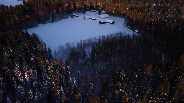 Aerial view of a house in a field covered in snow surrounded by a forest in the city of Pite&aring; in the north of Sweden