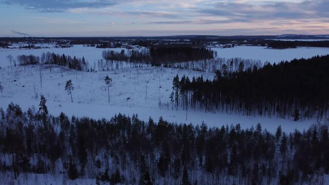 4K aerial flying above a snow-covered landscape during blue hour in Pite&aring;, Sweden