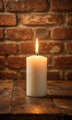 White candle glowing softly against a brick wall.