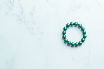 Elegant Green Beaded Bracelet Displayed on Marble Surface for Fashion and Accessory Marketing