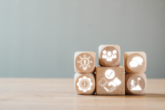 Wooden blocks with icons symbolizing essential soft skills for effective communication, teamwork, and leadership in a professional environment.