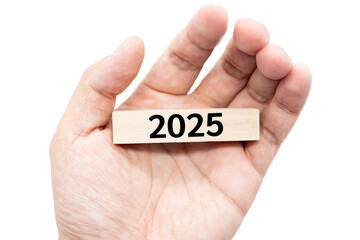 Text 2025 wooden block on hand with Clipping path isolated on white background.