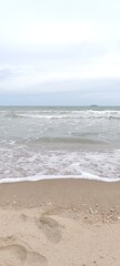 Sunny beach with waves gently rolling onto the shore
