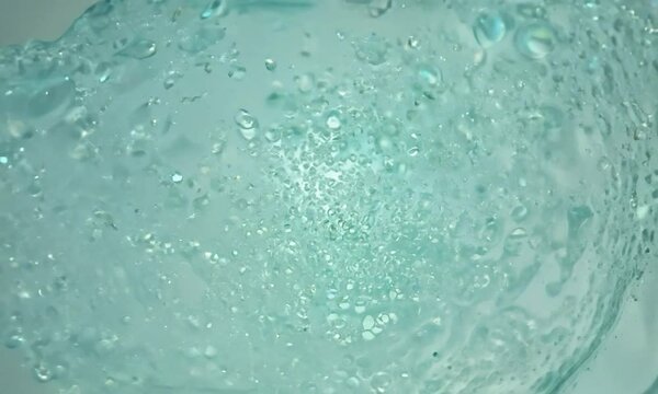 Zoom shot with micro-particle interactions in a gel: The camera starts with a view of micro-particles in a gel medium. The camera zooms in to show how the particles move and interact within the gel, i