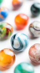 A variety of colorful glass marbles are arranged on a white background, displaying their intricate patterns and vibrant hues