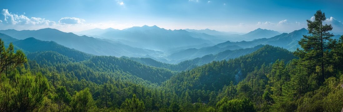 Panoramic view of a lush green mountain range under a blue sky with white clouds.