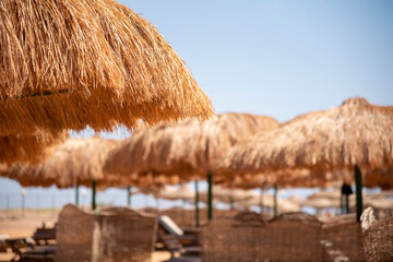 Straw beach umbrellas. Blurred background.