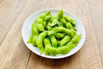 木目のダイニングテーブルと枝豆のおつまみ