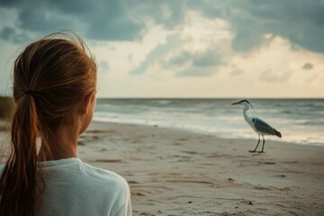 Obraz premium Child Watching Heron by the Ocean Shore