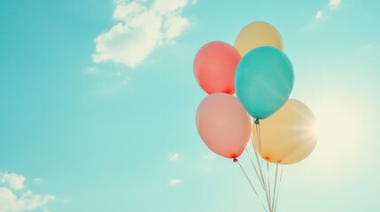 Obraz premium Colorful Balloons Floating Against Bright Blue Sky