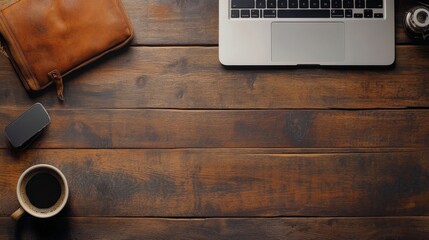 Top view of a wooden desk with a laptop, coffee cup, and a leather bag.