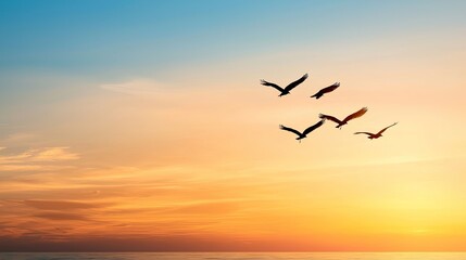 Fototapeta premium A serene sunset sky with five birds soaring gracefully, creating a peaceful and harmonious scene over the horizon.