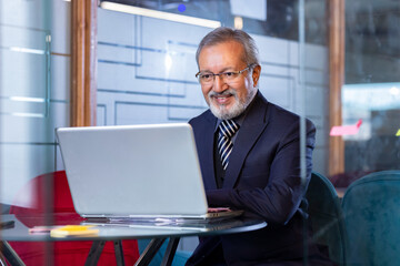 Senior software developer working on a laptop in an office