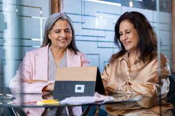 Senior Businesswoman discussing while using digital tablet in office