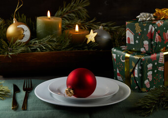 Christmas decor: red balloon, candles, gifts on  linen tablecloth