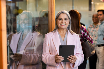 Fototapeta premium Close-up portrait of a senior smiling business woman standing in the office