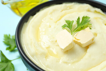 Mashed potatoes with butter in bowl on blue background, close up