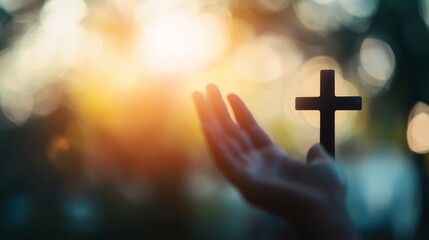 Worship God concept: Silhouette christian people hand rising over blurred cross on spiritual light background