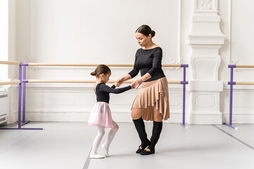 Obraz premium Ballet training of little girl with teacher practicing before ballet performance