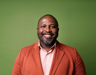 Studio Portrait of Handsome Mature Man Happily Smiling Against Green Background