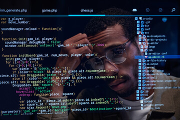 Man focused on analyzing code displayed on multiple screens with reflections in glasses. Lines of code visible in foreground showing complex programming process