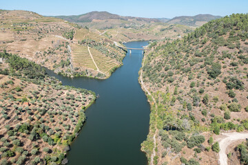 Ponte e cais da Brunheda ao fundo do serpenteante rio Tua, um encontro pitoresco de natureza e infraestrutura em Trás-os-Montes, Portugal © LuIvDa
