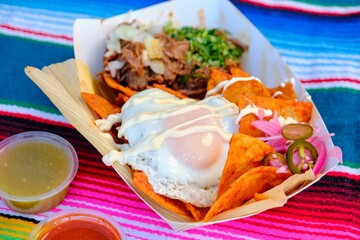 Fresh Mexican tacos topped with a perfectly fried egg on colorful surface