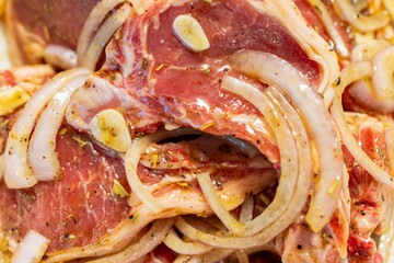 Close up of lamb ribs marinated with sliced onion, garlic, and spices The fresh meat is seasoned...