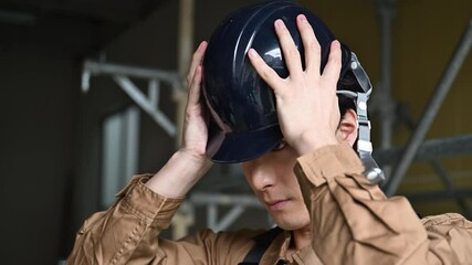Cool slow video of a worker at a job site putting on his helmet. Be safe! Close-up