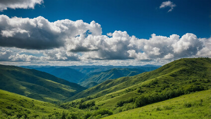Lush green mountains under a bright blue sky with fluffy white clouds, creating a serene and open landscape.