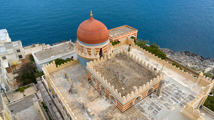 Aerial view of a Moorish palace with a sea view. There is a beautiful orange dome.