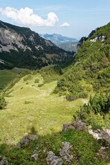 Scenic green valley with rocky mountains.