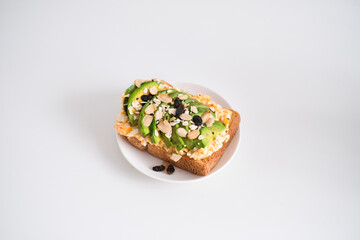 Avocado sandwich with scrambled eggs, sliced avocado and egg on toasted bread for healthy breakfast or snack.