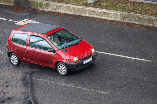 Red renault twingo driving on the road